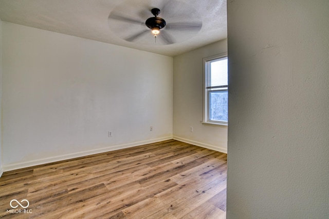 empty room with ceiling fan and light hardwood / wood-style flooring