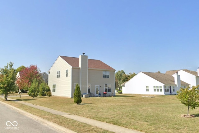 rear view of property featuring a yard