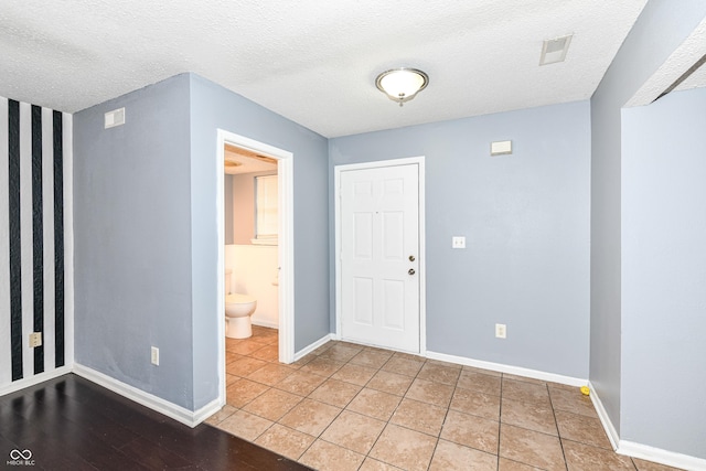 entrance foyer featuring light tile patterned flooring and a textured ceiling