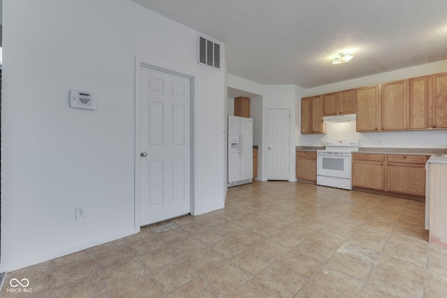 kitchen featuring light brown cabinets and white appliances