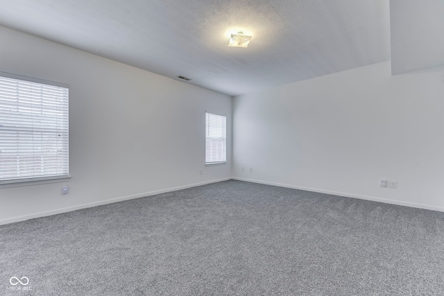 carpeted spare room featuring a textured ceiling