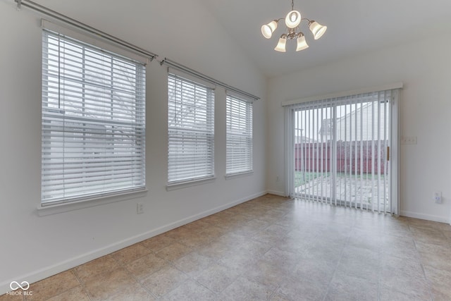 empty room with a chandelier and vaulted ceiling