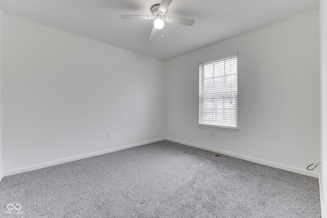 carpeted spare room with ceiling fan