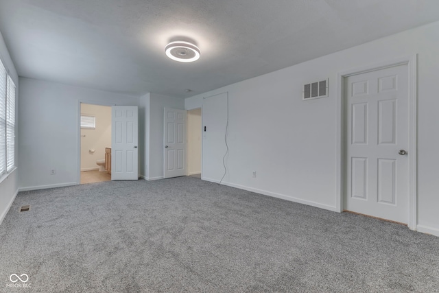 interior space with carpet flooring and ensuite bathroom