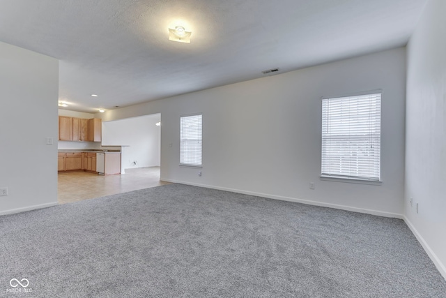 unfurnished living room with a healthy amount of sunlight and light colored carpet