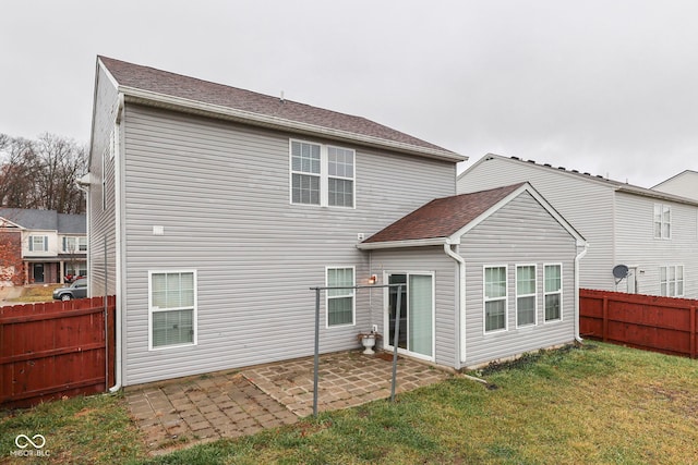 rear view of property featuring a yard and a patio area