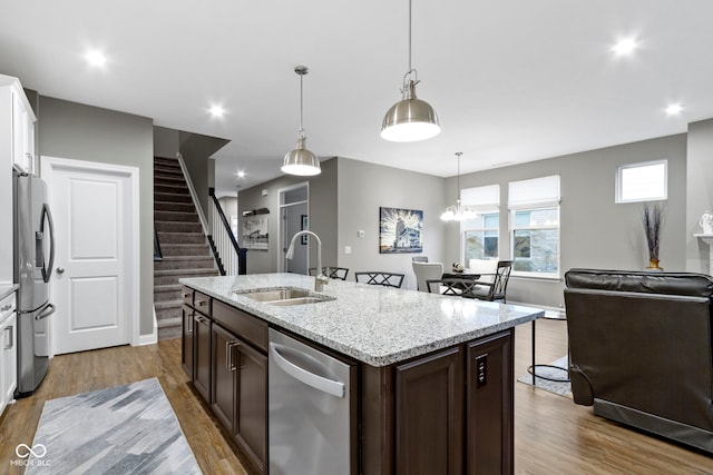 kitchen featuring pendant lighting, white cabinets, sink, dark brown cabinets, and stainless steel appliances