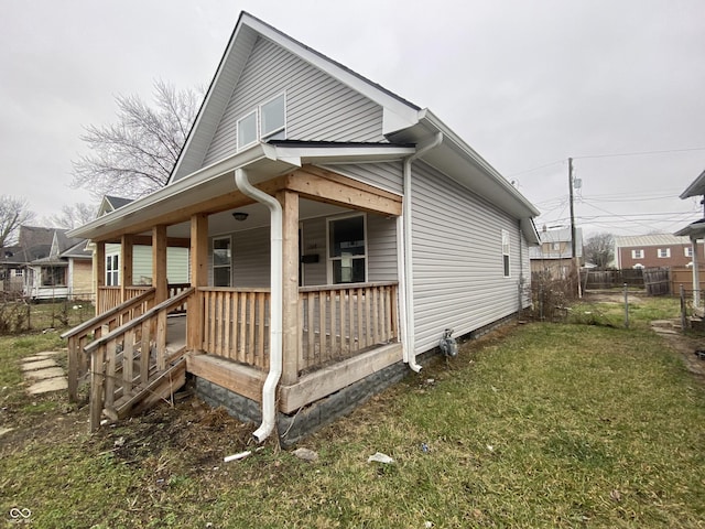 view of side of property with a lawn and a porch