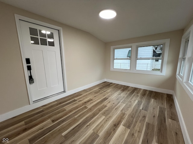 entrance foyer featuring wood-type flooring and lofted ceiling