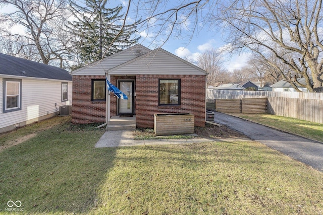 bungalow-style house featuring central air condition unit and a front lawn