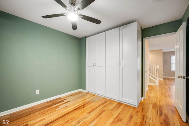 unfurnished bedroom featuring ceiling fan, a closet, and light hardwood / wood-style floors