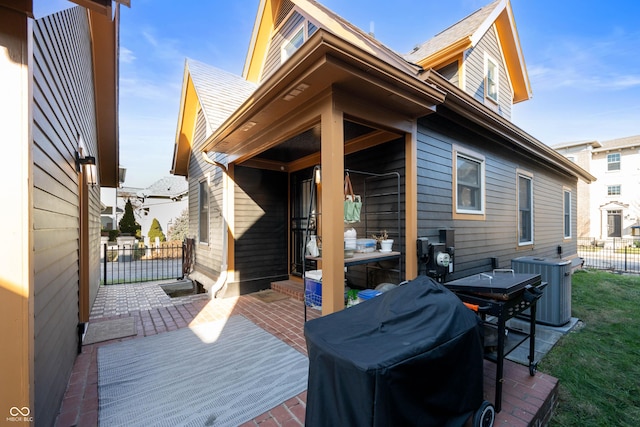 wooden terrace featuring area for grilling, a patio area, and central AC unit