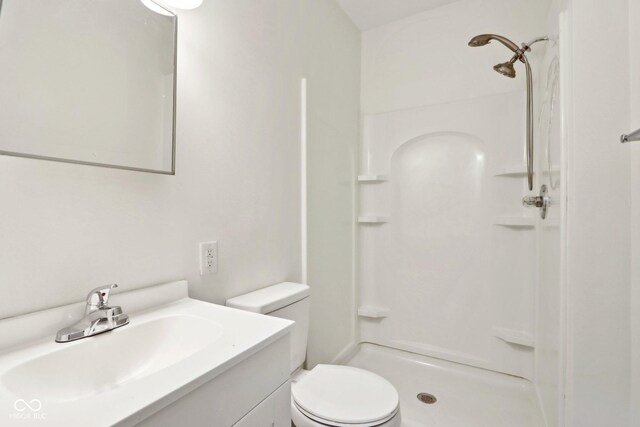 bathroom featuring walk in shower, vanity, and toilet