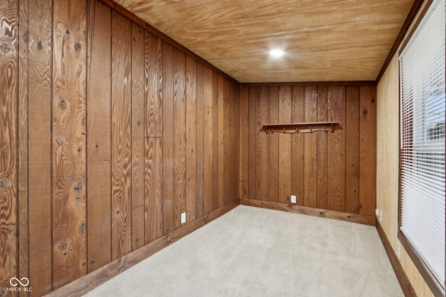 carpeted spare room with wood walls and wood ceiling