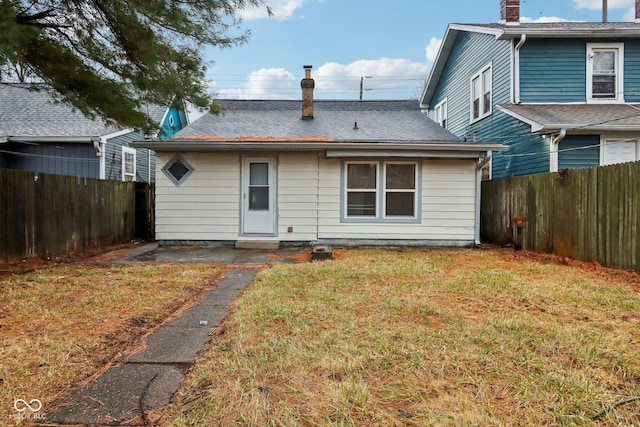 rear view of house featuring a yard