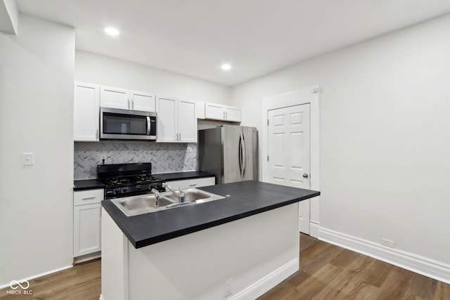 kitchen featuring dark wood finished floors, dark countertops, appliances with stainless steel finishes, and white cabinets