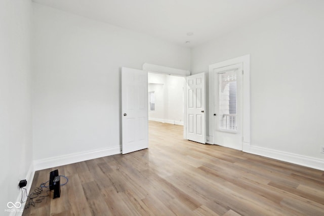 unfurnished bedroom featuring wood finished floors and baseboards