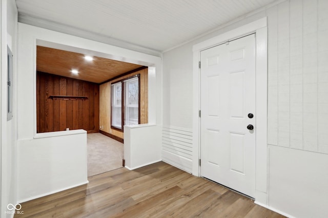 foyer entrance with wood finished floors and wooden walls
