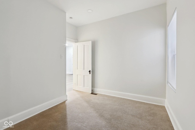 carpeted empty room with baseboards and visible vents