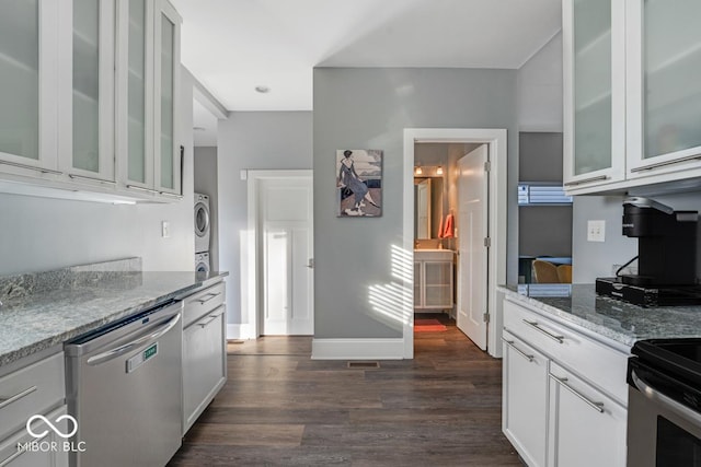 kitchen with dishwasher, light stone counters, white cabinetry, and stacked washer and clothes dryer