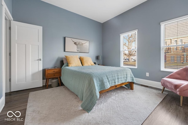 bedroom with dark hardwood / wood-style floors