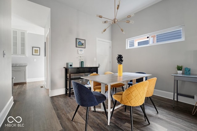 dining area featuring lofted ceiling, dark wood-type flooring, and a chandelier