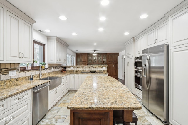 kitchen featuring a center island, sink, white cabinetry, and stainless steel appliances