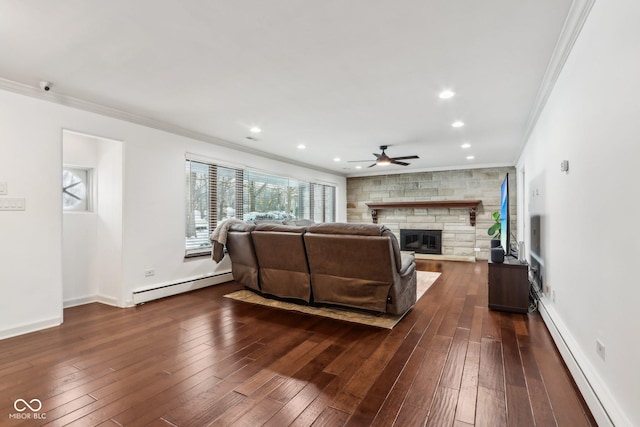 living room featuring a stone fireplace, crown molding, and a baseboard radiator