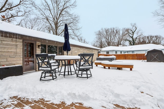 yard covered in snow with a storage unit