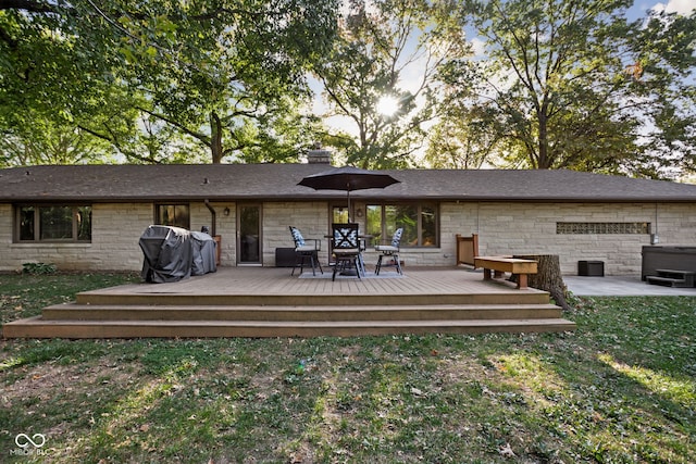 rear view of property with a deck and a yard