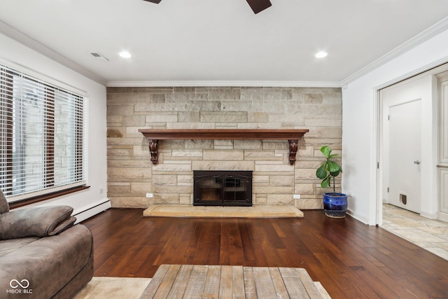 unfurnished living room featuring hardwood / wood-style flooring, ornamental molding, a fireplace, and a baseboard heating unit