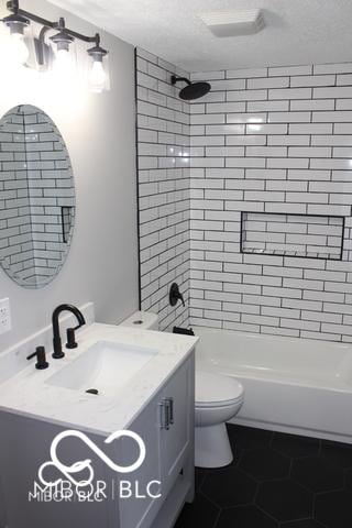 full bathroom with toilet, a textured ceiling, tiled shower / bath combo, and tile patterned floors