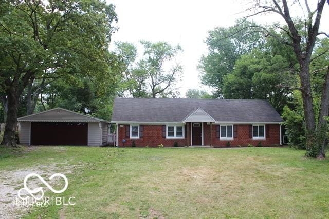 ranch-style home with a garage, an outbuilding, and a front yard