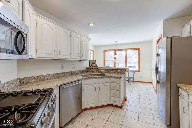 kitchen featuring white cabinets, stainless steel appliances, sink, hanging light fixtures, and kitchen peninsula