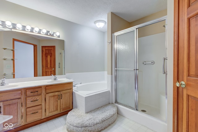 bathroom featuring vanity, a textured ceiling, and shower with separate bathtub