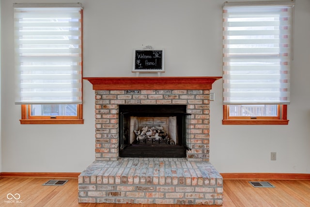 details with wood-type flooring and a brick fireplace