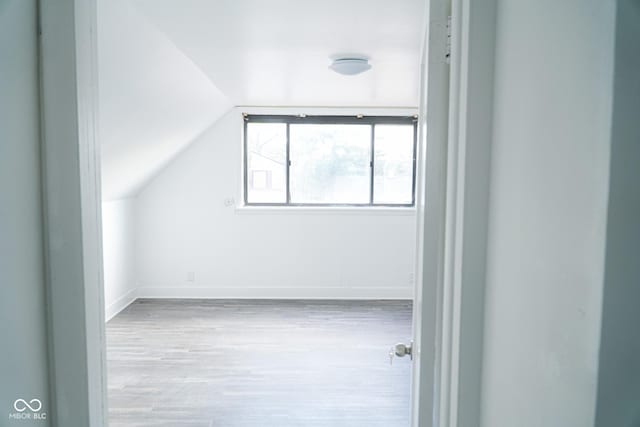 bonus room featuring lofted ceiling and light hardwood / wood-style flooring