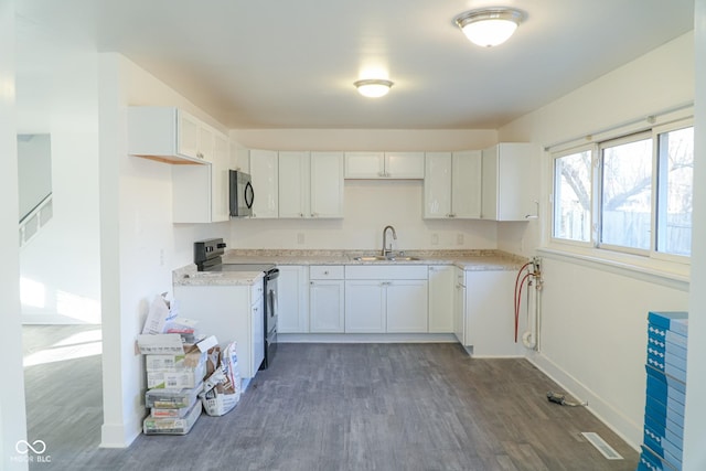 kitchen featuring dark hardwood / wood-style flooring, white cabinetry, sink, and black range with electric cooktop