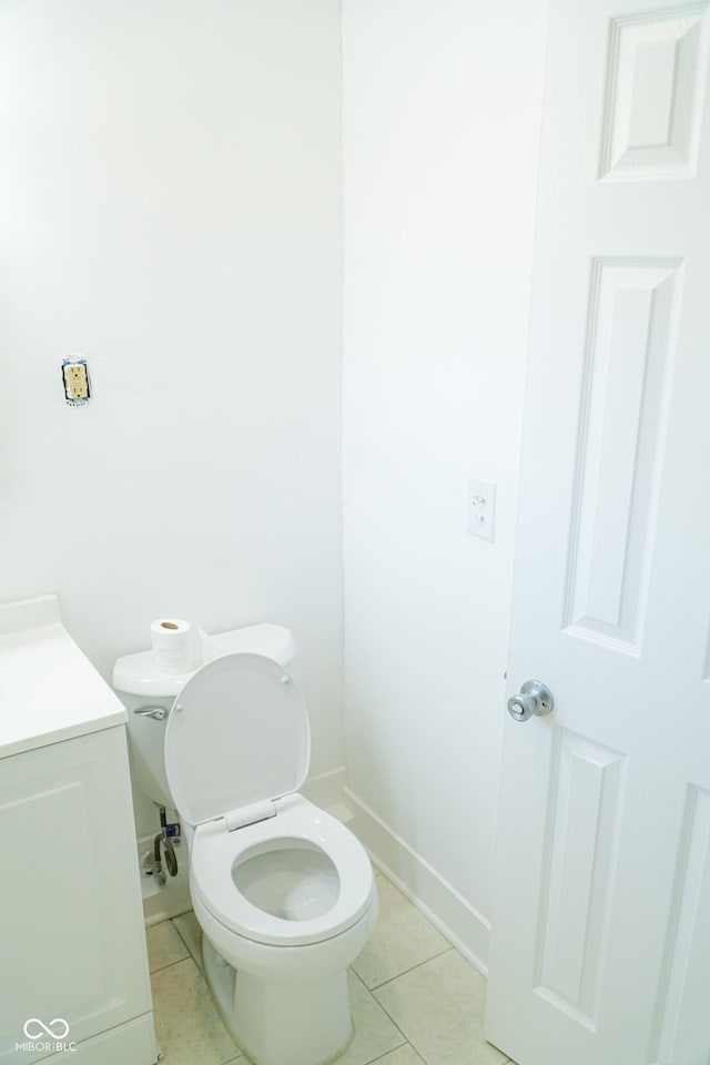 bathroom with toilet, vanity, and tile patterned floors