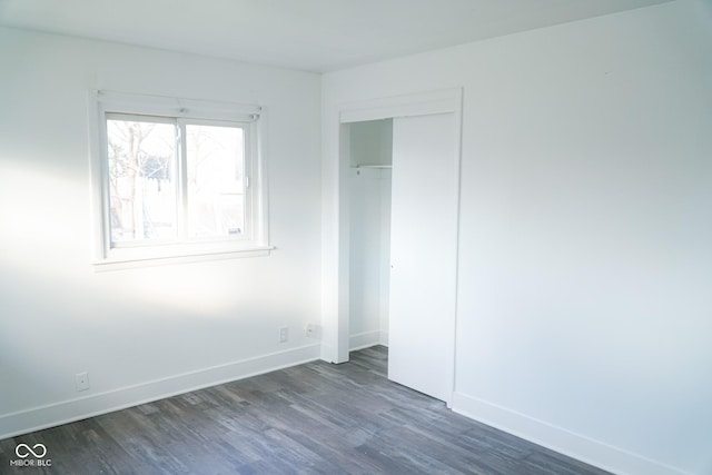 unfurnished bedroom with a closet and dark hardwood / wood-style floors