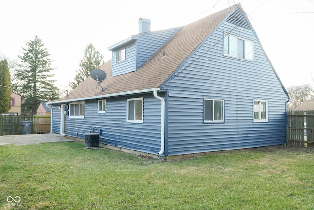 back of house featuring central AC and a lawn