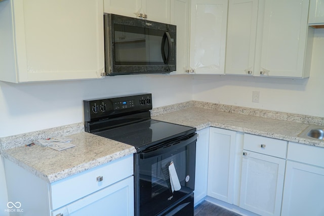 kitchen featuring black appliances, white cabinets, and sink