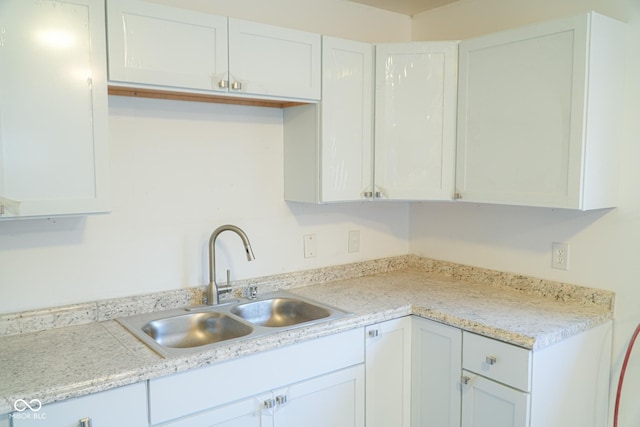 kitchen featuring white cabinetry and sink