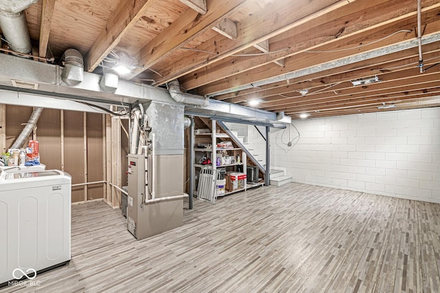 basement featuring heating unit and washer / dryer