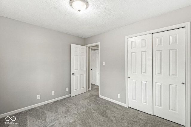 unfurnished bedroom featuring a textured ceiling, light carpet, and a closet