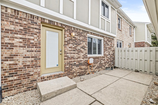 view of exterior entry with a patio