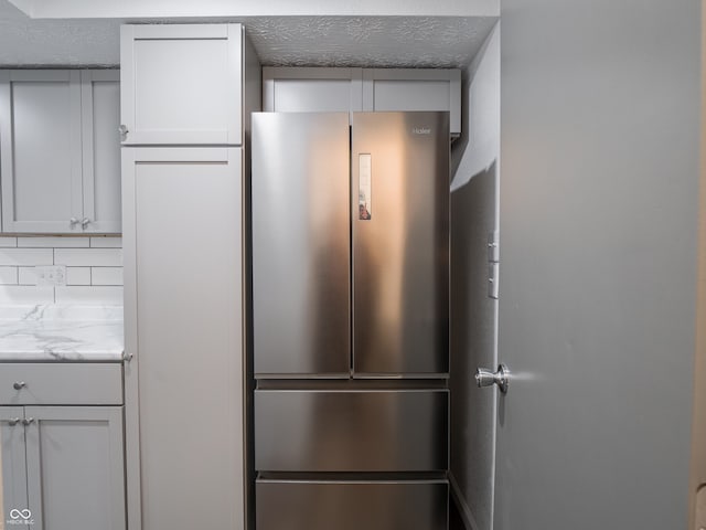 kitchen with backsplash and stainless steel refrigerator