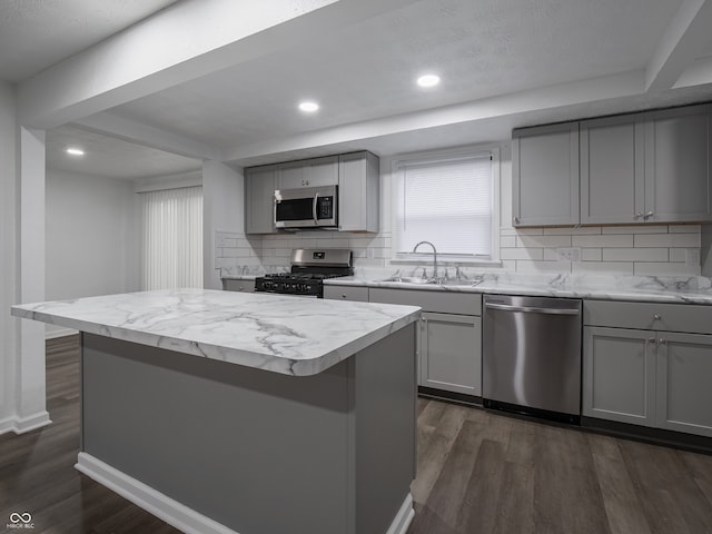 kitchen with gray cabinets, sink, a kitchen island, and stainless steel appliances