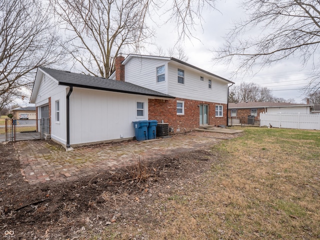 rear view of property featuring a lawn and central air condition unit