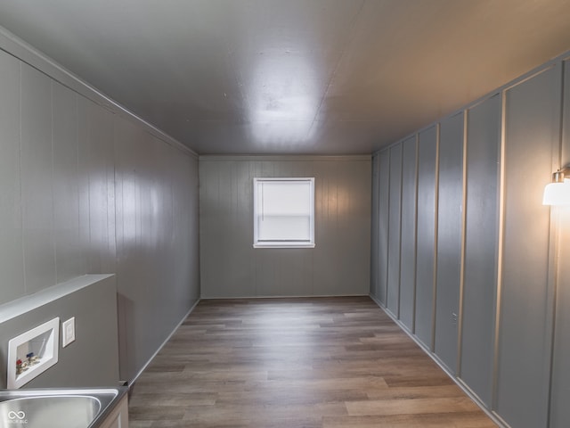 empty room featuring sink and light hardwood / wood-style flooring